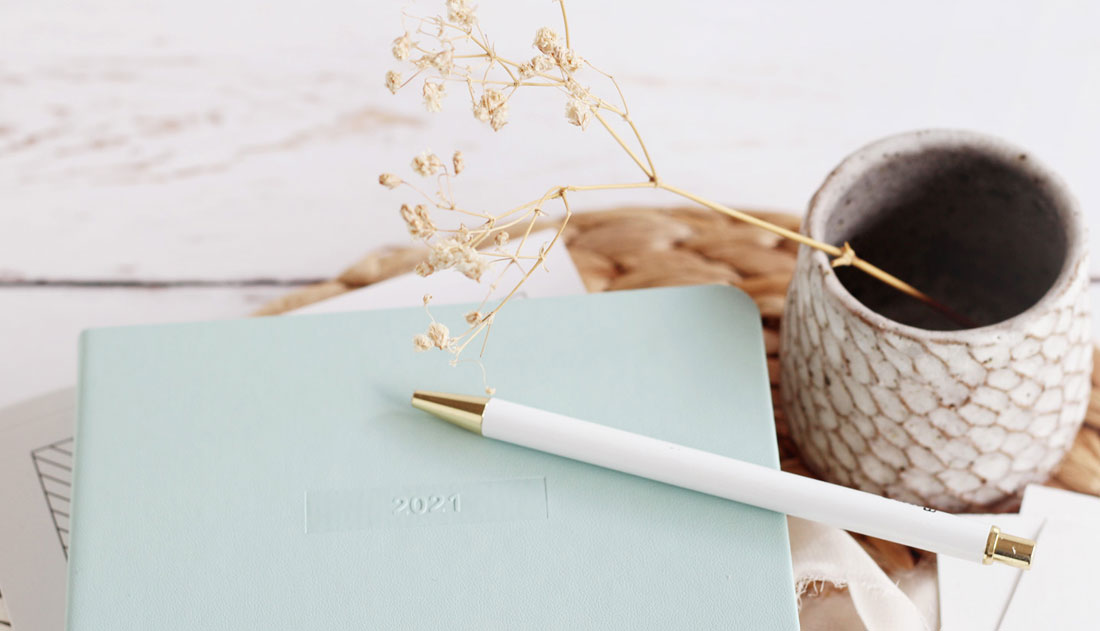 white pen on blue journal